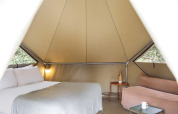 Innenansicht des Bell Tents bei Wecamp Pirineos in Spanien mit Bett, Sofa und Tisch im Safarizelt.