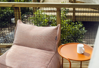 Espace détente extérieur sur une terrasse en bois près d’une tente safari à Wecamp Pirineos, Espagne.