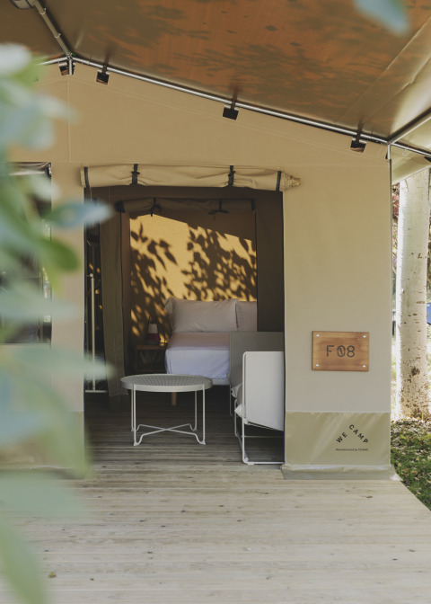 Tienda safari «Cottage Family Tent» en Wecamp Pirineos, España, con cama y zona de estar exterior.