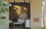 Safari-telt 'Cottage Family Tent' hos Wecamp Pirineos i Spanien, med seng og udendørs siddeplads.