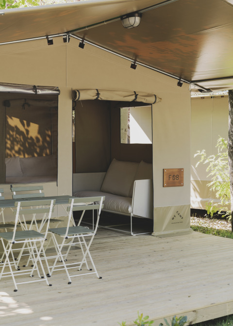 Safari telt Cottage Family Tent ved Wecamp Pirineos, Spanien, med udendørs siddeplads og stole.