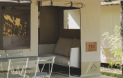 Tienda safari Cottage Family Tent en Wecamp Pirineos, España, con terraza y sillas al aire libre.