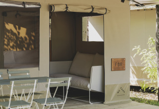 Safari telt Cottage Family Tent ved Wecamp Pirineos, Spanien, med udendørs siddeplads og stole.