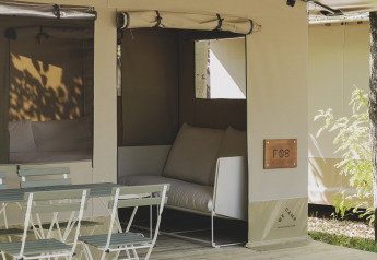 Safari telt Cottage Family Tent ved Wecamp Pirineos, Spanien, med udendørs siddeplads og stole.