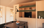 Interieur van een Lodge Family Plus safaritent bij Wecamp Cádiz, Spanje, met eettafel en keukenhoek.
