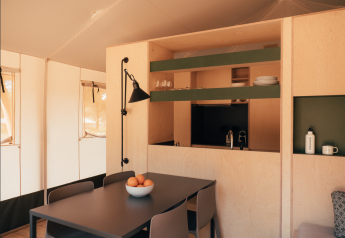 Moderne indretning af et safari telt Lodge Family Plus på Wecamp Cádiz, Spanien, med spisebord og køkken.