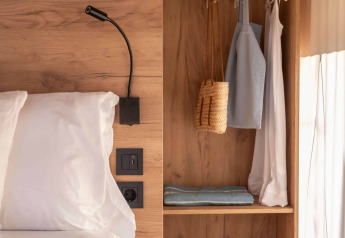 Interni di una tenda safari Glamping Couple al Wecamp Cádiz in Spagna, con letto, armadio e luce naturale.