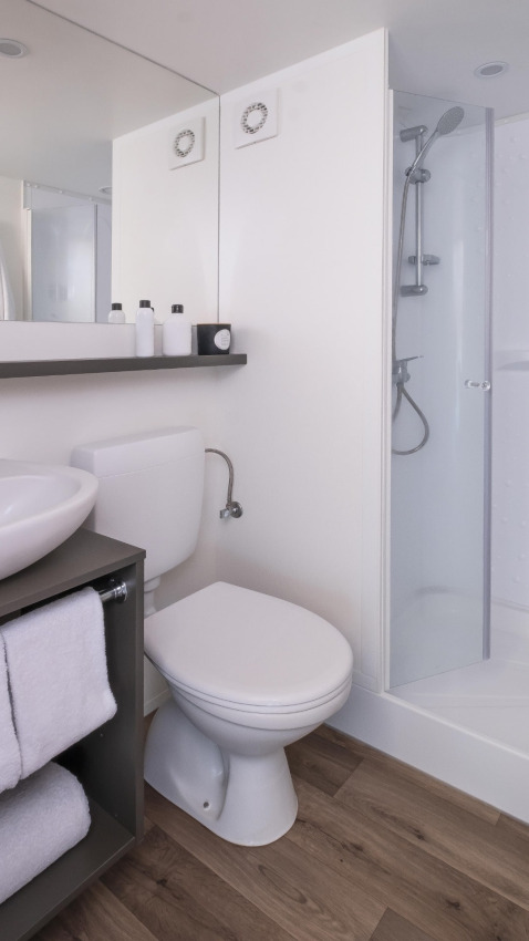Modern bathroom in the Glamping Couple safari tent at Wecamp Cádiz, Spain, featuring a shower and wood floor.