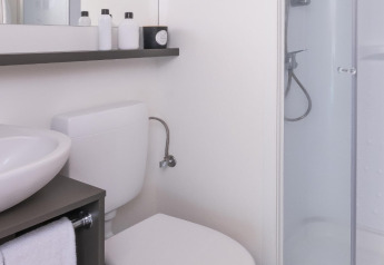 Bagno moderno nella tenda safari Glamping Couple a Wecamp Cádiz, Spagna, con doccia e pavimento in legno.