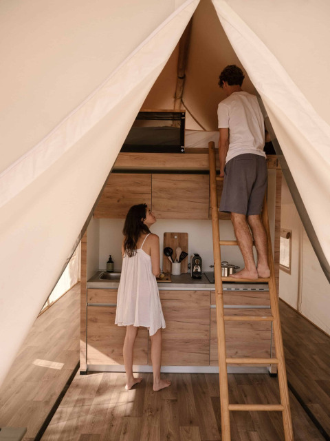 In een Glamping Comfort safaritent bij Wecamp Cádiz in Spanje staat een stel in een knusse kitchenette.