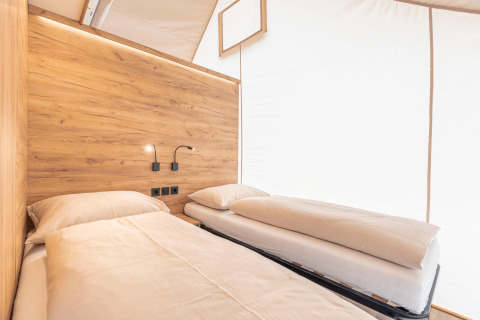 Vista interna dell’area notte presso Chalets & Glamping Nassfeld 5, con letti singoli e rivestimento in legno.