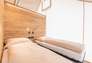 Vista interna dell’area notte presso Chalets & Glamping Nassfeld 5, con letti singoli e rivestimento in legno.