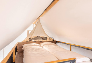 Vista interna della zona notte in una tenda safari ai Chalets & Glamping Nassfeld 6 in Austria.