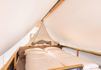 Interieur van het slaapgedeelte in een safaritent bij Chalets & Glamping Nassfeld 6 in Oostenrijk.