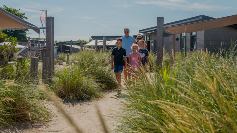 Eine Familie spaziert durch die Dünen am Dune Lodge im EuroParcs Parc du Soleil in den Niederlanden im Sommer.