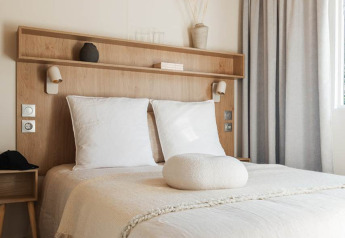 Habitación glamping moderna y luminosa con cama doble, techo de madera y decoración minimalista natural.