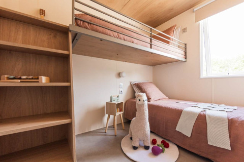 Moderne lodgekamer in Sunset Lodge, Vakantiepark Leukermeer met stapelbed, raam en speellama.