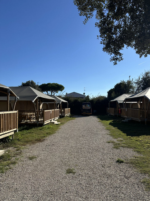 Grindpad tussen safaritenten bij Cottage, Vigna sul Mar Family Camping Village, Italië, op een zonnige dag.