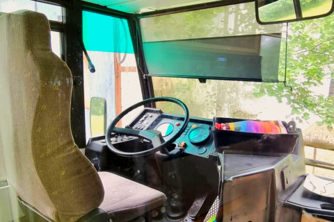 Bestuurderszetel en dashboard in het mobiele huis REEBUS in België, gezien door het voorraam.