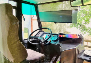 Bestuurdersstoel en dashboard van het REEBUS mobiel huis in België, gezien door het voorraam.