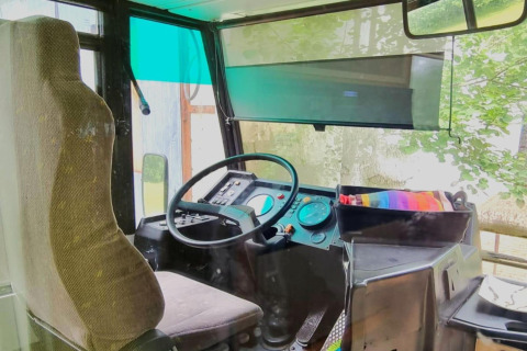 Førerhuset i mobilhjemmet REEBUS i Belgien viser førersædet, rat og instrumentbræt gennem ruden.