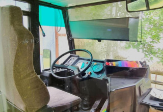 Førerhuset i mobilhjemmet REEBUS i Belgien viser førersædet, rat og instrumentbræt gennem ruden.