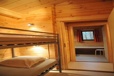 Photo intérieure d'un chalet en bois à De Boshut, Belgique, avec des lits superposés et une fenêtre.