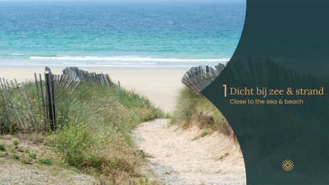 Pad door grasduinen met houten hekken naar het strand en de zee bij een glamping accommodatie.