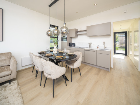 Cuisine et salle à manger modernes de lodge avec suspensions, sols en bois clair et décoration élégante.