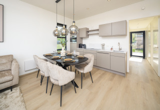 Modernes Lodge-Küche und Essbereich mit Pendelleuchten, hellen Holzböden und stilvollem Design.