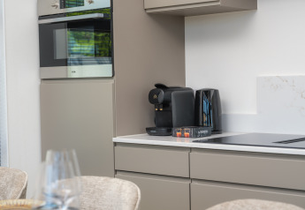 Moderne Küchenzeile in einer Lodge mit Backofen, Kaffeemaschine und Wasserkocher auf der Arbeitsplatte.