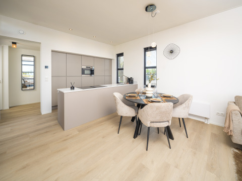Modernes Lodge-Küche und Essbereich mit hellen Holzfußböden, stilvollen Möbeln und eleganter Dekoration.