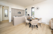Modernes Lodge-Küche und Essbereich mit hellen Holzfußböden, stilvollen Möbeln und eleganter Dekoration.