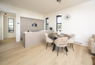 Modernes Lodge-Küche und Essbereich mit hellen Holzfußböden, stilvollen Möbeln und eleganter Dekoration.