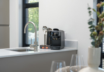 Encimera de cocina moderna en una lodge con cafetera Philips, fregadero y decoraciones elegantes en primer plano.