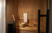 Sauna de madera con toalla, cubo y piedras en Villa Meerzicht, MarinaPark Beach Resort Soal, Países Bajos.