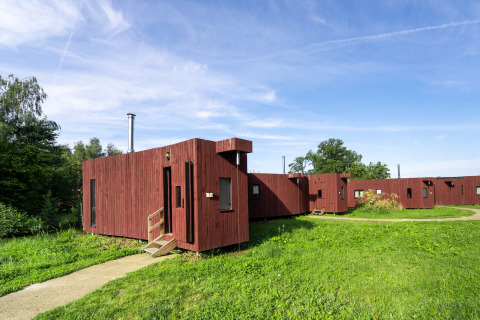 Glamping accommodatie The Large Leaf van YourNature met moderne houten hutten in een groene omgeving.