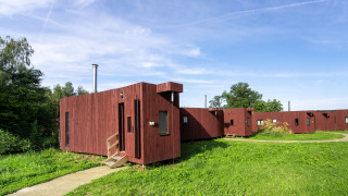Glamping accommodatie The Large Leaf van YourNature met moderne houten hutten in een groene omgeving.