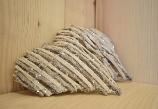 Cuori decorativi in legno in un angolo di La roulotte des Ardennes in Belgio, creano un'atmosfera accogliente.
