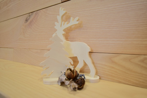 Decorazione in legno con una renna e un albero su una mensola a La roulotte des Ardennes in Belgio.