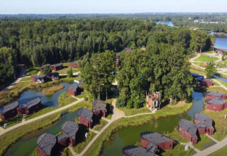 Luchtfoto van The Leaf by YourNature lodge in België met ronde huisjes, bomen en waterpartijen.