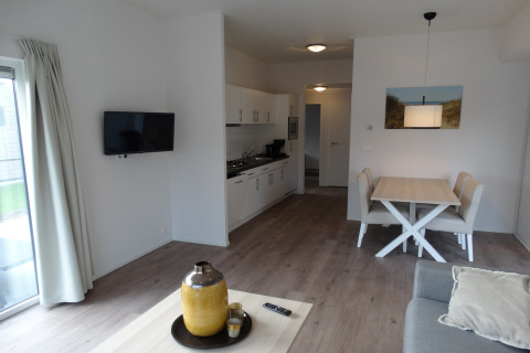 Moderne woonkamer en keuken in het Breeduyn Village 3 lodge in België, met lichte inrichting.