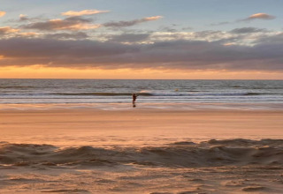 Zonsondergang op het strand bij Breeduyn Village 3 in België, zacht licht over zee en zand.