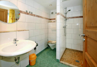 Lichte badkamer van Bungalow '35 qm 2 Pers' in Duitsland met douche, wc en groene tegels.