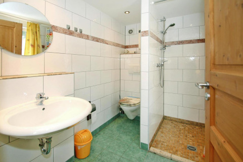 Lichte badkamer van Bungalow '35 qm 2 Pers' in Duitsland met douche, wc en groene tegels.