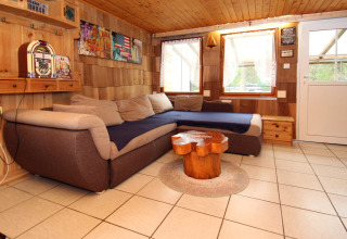 Soggiorno accogliente con divano angolare e arredi in legno presso Susanne 58 qm, Germania.