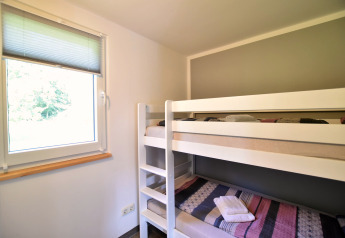 Room with bunk bed and a window at the 'Gänseblümchen 6' bungalow complex in Germany.