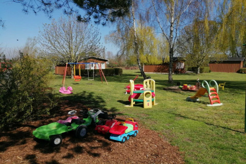 Parco giochi con altalene, scivolo e macchinine nel giardino del complesso Gänseblümchen 6 in Germania.