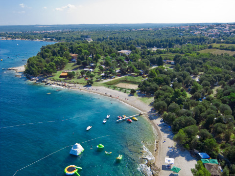 Luftaufnahme des Camping Brioni Ferienparks in Istrien, Kroatien, mit Strand, Meer und Bäumen.