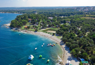 Vista aerea del Camping Brioni a Istria, Croazia, con spiaggia, costa blu e ampie zone verdi.